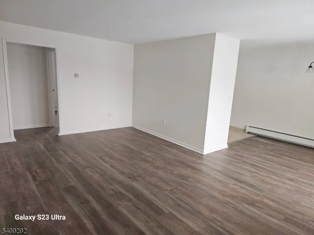 a view of an empty room with wooden floor