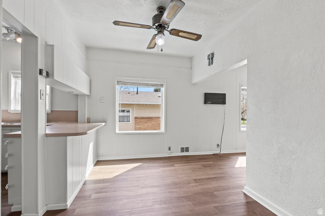 180 South 300 East Logan, UT 84321 - Photo 7 of 35 Unfurnished living room featuring vinyl floors, a ceiling fan, a textured wall, and a textured ceiling
