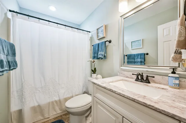 a bathroom with a granite countertop sink toilet and shower