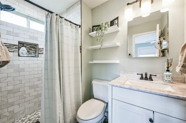 a bathroom with a sink a toilet and shower curtain