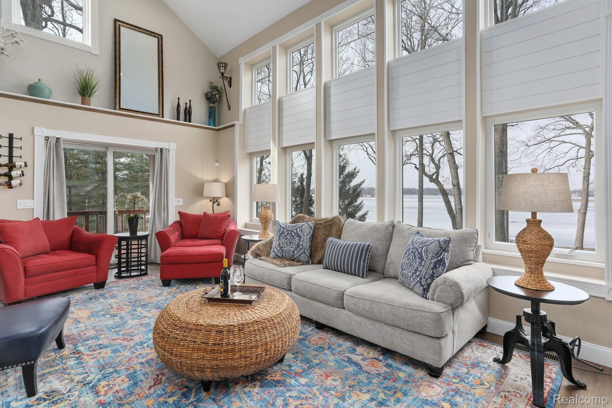 4485 Cordley Lake Road Pinckney, MI 48169 - Photo 13 of 35 Family room with two story windows with view of lake and slider to covered porch