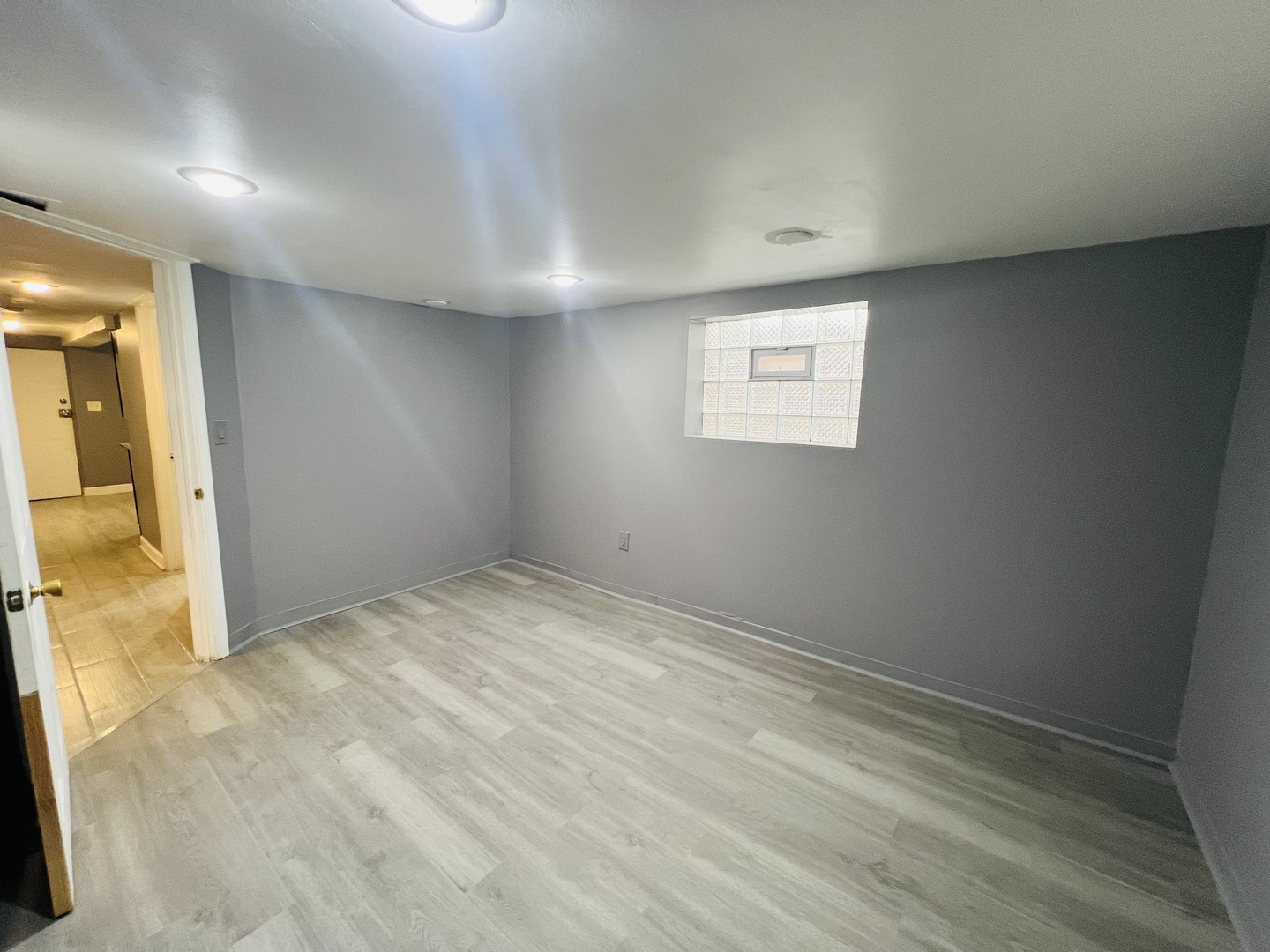 3516 North Keating Avenue, Unit G Chicago, IL 60641 - Photo 9 of 20 an empty room with wooden floor and a bathroom view