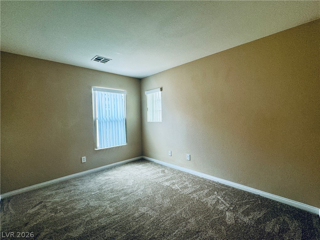 8617 Palomino Ranch Street Las Vegas, NV 89131 - Photo 15 of 27 A quiet bedroom offers comfort with soft carpet and natural light filtering through the windows.