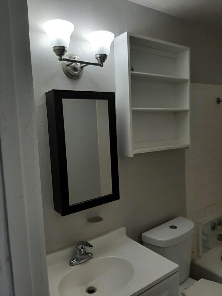 2403 East 5th Street Lubbock, TX 79403 - Photo 3 of 8 a bathroom with a sink a toilet and a mirror