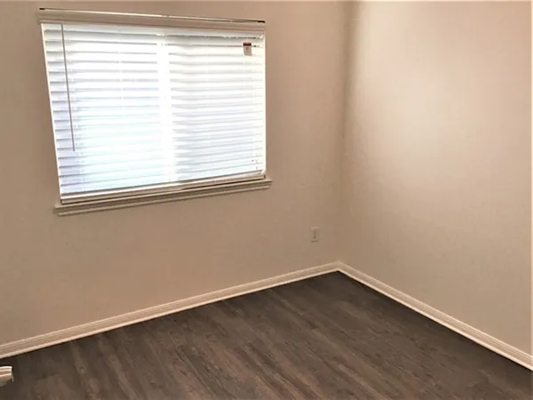 a view of a small space with wooden floor and a window