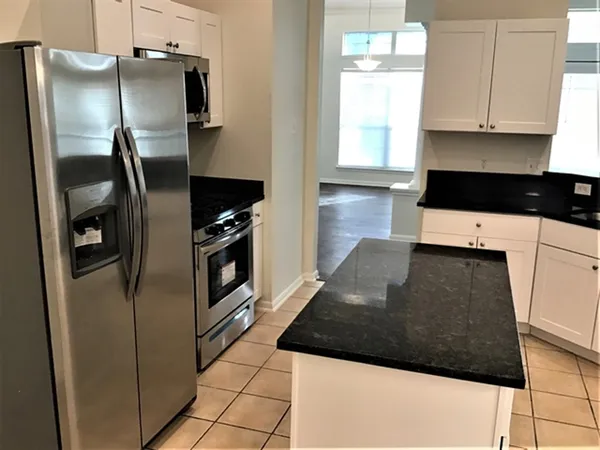 a kitchen with a refrigerator a stove a microwave and cabinets