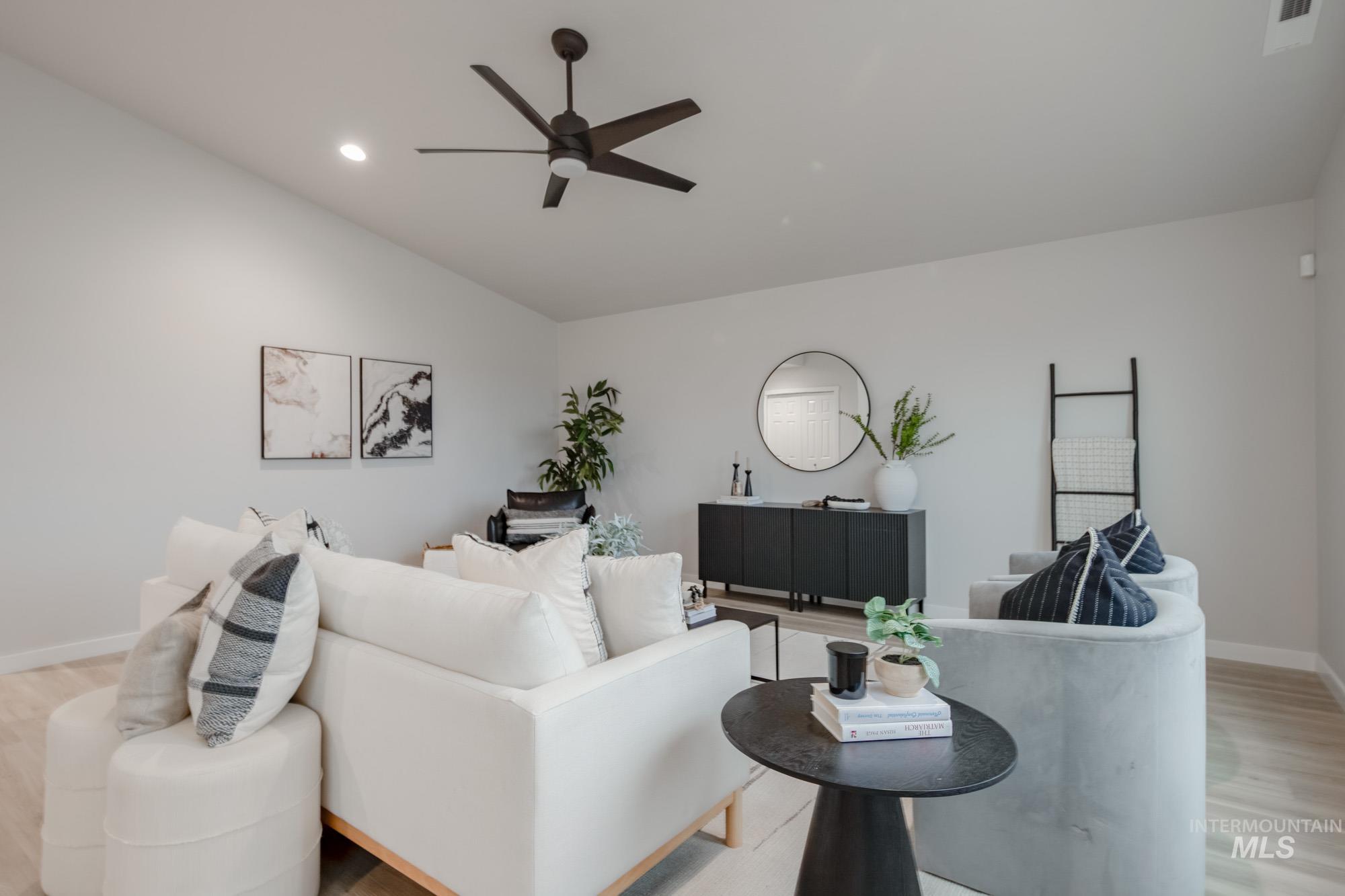 1776 West Unforgettable Street Meridian, ID 83642 - Photo 17 of 28 Living area featuring light wood finished floors, ceiling fan, and vaulted ceiling