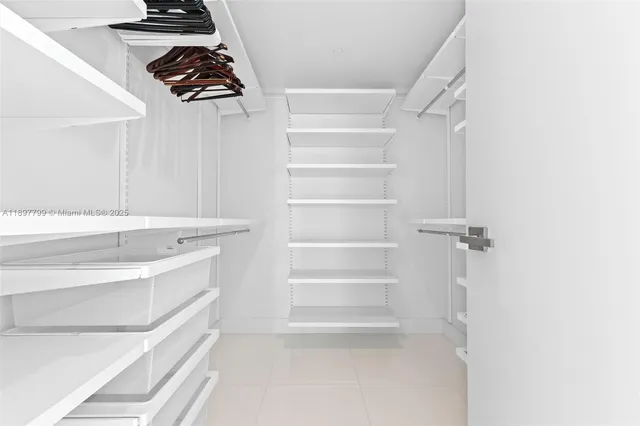 a view of walk in closet with empty racks