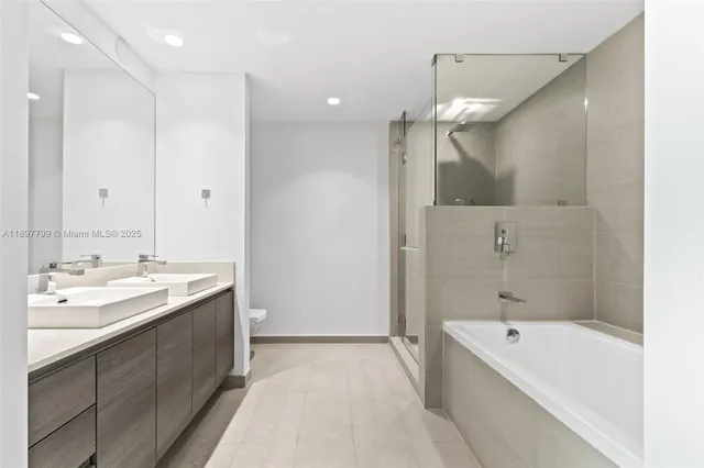 a bathroom with a tub a sink shower and mirror