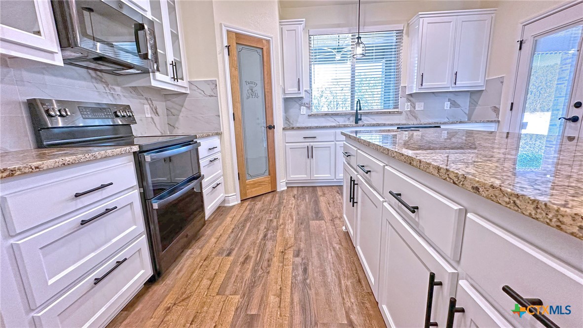 4237 Cool Basin Road Kempner, TX 76539 - Photo 8 of 36 a kitchen with granite countertop wooden floors appliances and sink