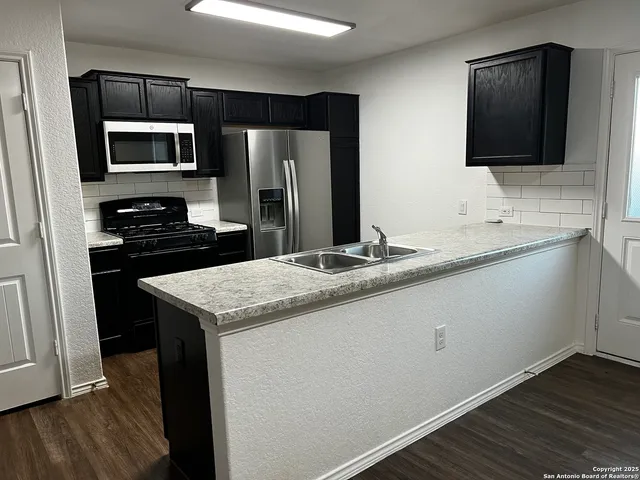 a kitchen with a sink microwave and refrigerator