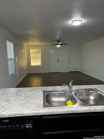 a kitchen with kitchen island granite countertop a sink stainless steel appliances and cabinets