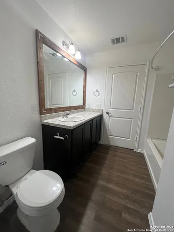 a bathroom with a granite countertop sink toilet and shower