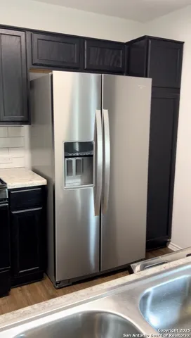 a metallic refrigerator freezer sitting in a kitchen