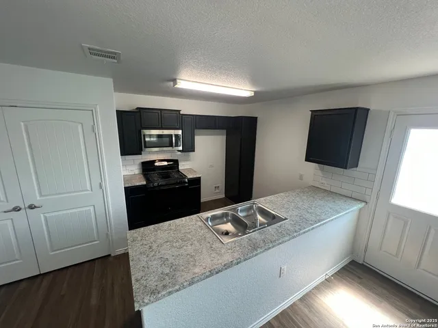 a kitchen with a sink stove and refrigerator