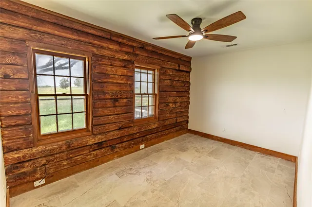 an empty room with window a ceiling fan and wooden floor