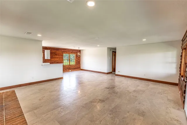 an empty room with wooden floor and window