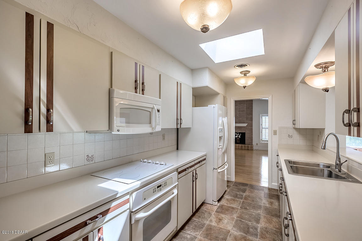 137 Reef Road South Daytona, FL 32119 - Photo 19 of 49 a kitchen with stainless steel appliances granite countertop a sink a stove and a refrigerator