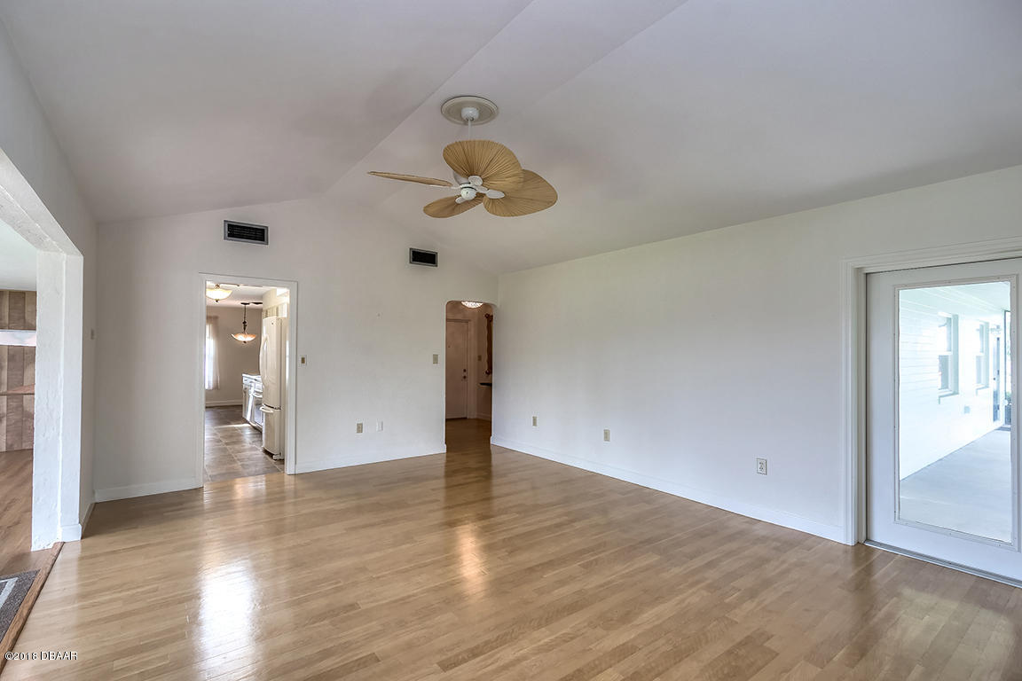 137 Reef Road South Daytona, FL 32119 - Photo 28 of 49 an empty room with wooden floor and ceiling fan