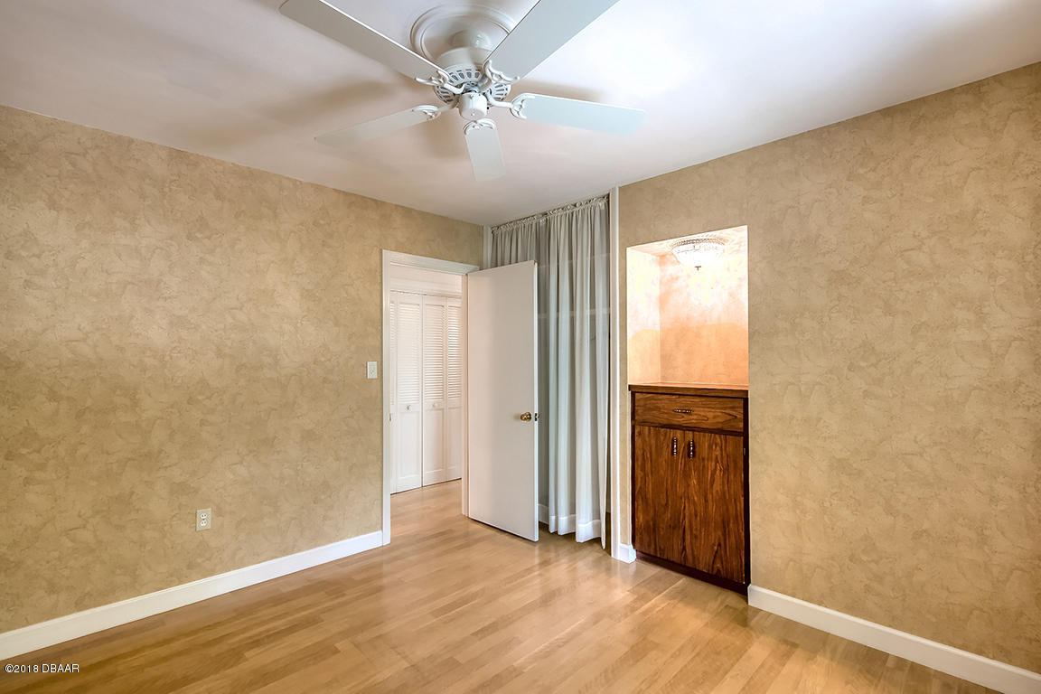 137 Reef Road South Daytona, FL 32119 - Photo 36 of 49 an empty room with wooden floor and ceiling fan