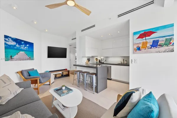 a kitchen with stainless steel appliances a stove a sink a refrigerator and white cabinets with wooden floor