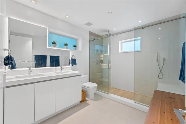 a bathroom with a sink a toilet and shower