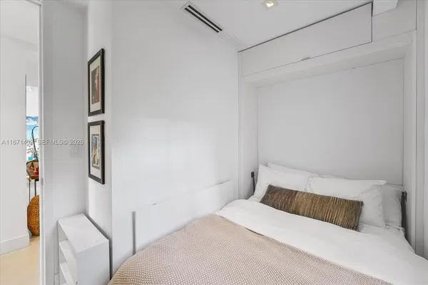 a bedroom with a bed and a painting on the wall