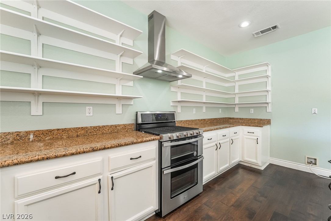 261 Timber Hollow Street Henderson, NV 89012 - Photo 20 of 51 Ample storage solutions define this kitchen, featuring expansive open shelving and durable granite countertops.