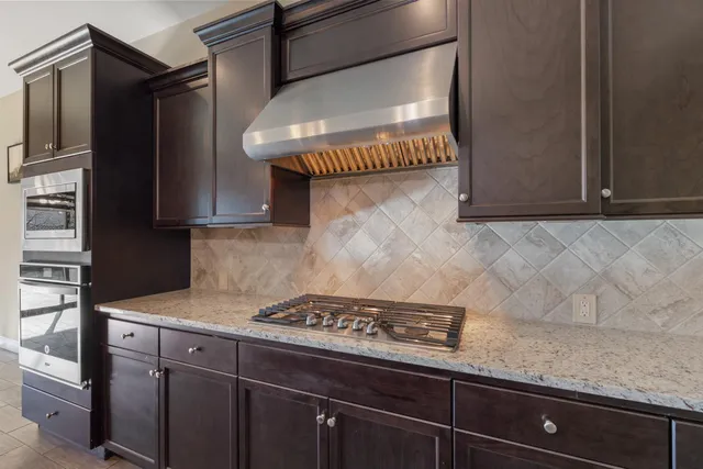 a kitchen with stainless steel appliances granite countertop a stove and a sink with granite countertops