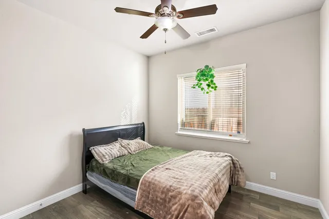 a bedroom with a bed and wooden floor