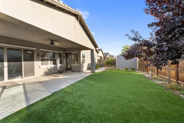 a view of a house with backyard and a tree