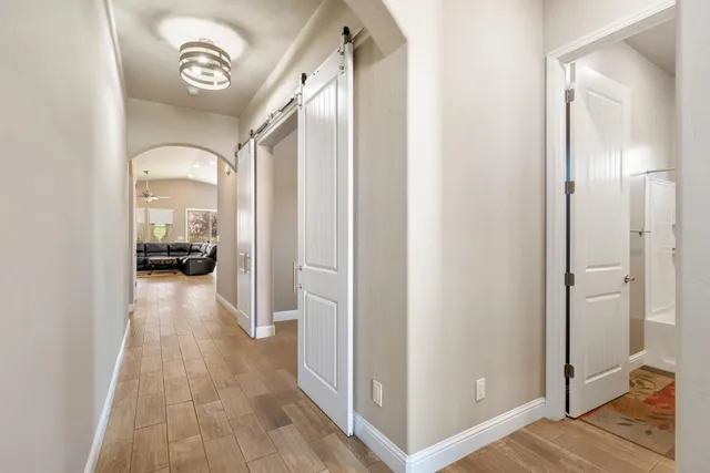 a view of a hallway with wooden floor and a bedroom