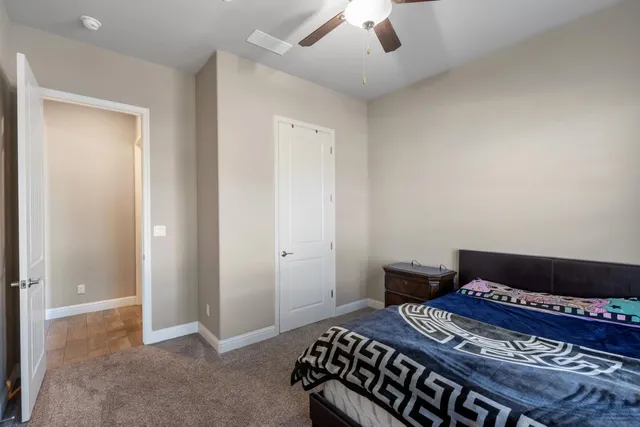 a bedroom with a bed and a chandelier fan