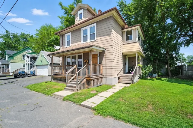a view of a house with a yard and sitting area