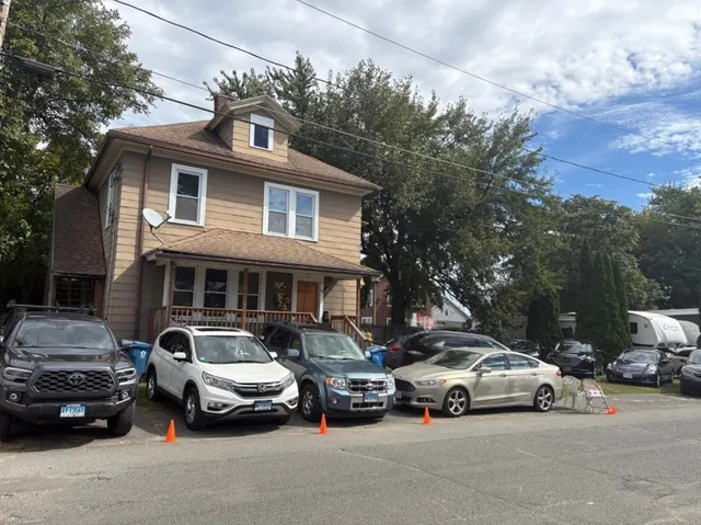 a couple of cars parked in front of a house