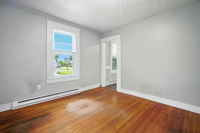 an empty room with window and wooden floor