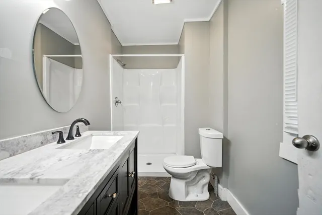 a bathroom with a granite countertop sink toilet and a mirror