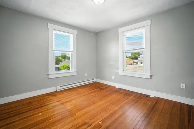 an empty room with window and wooden floor