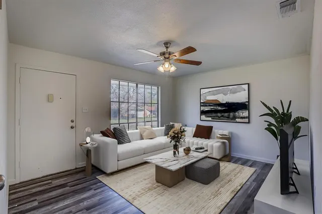 a living room with furniture a chandelier and a potted plant