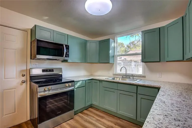 a kitchen with a sink cabinets and wooden floor