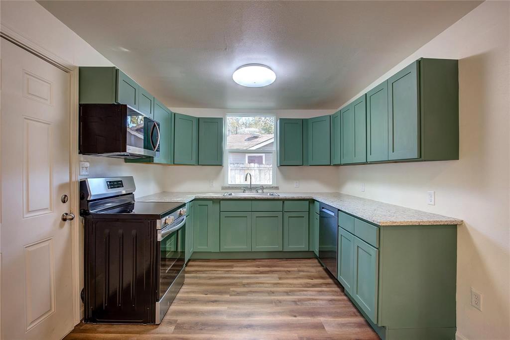 1908 Division Street Greenville, TX 75401 - Photo 10 of 11 a kitchen with a sink cabinets and wooden floor