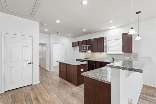a kitchen with stainless steel appliances granite countertop a sink stove and refrigerator