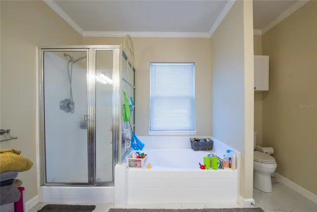 a bed sitting in a spacious bedroom next to a window