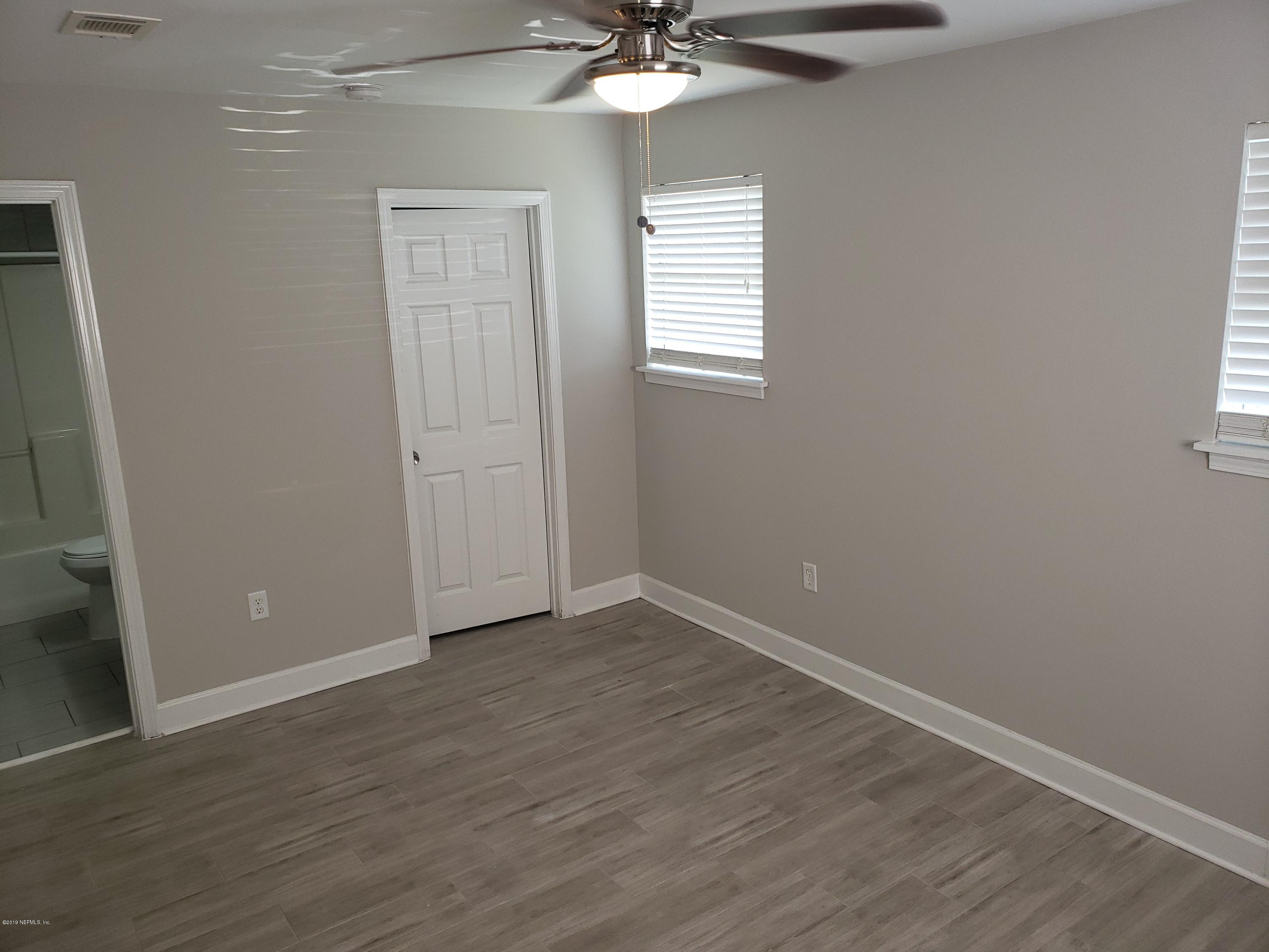 4030 Springwood Road Jacksonville, FL 32207 - Photo 5 of 19 an empty room with wooden floor and windows