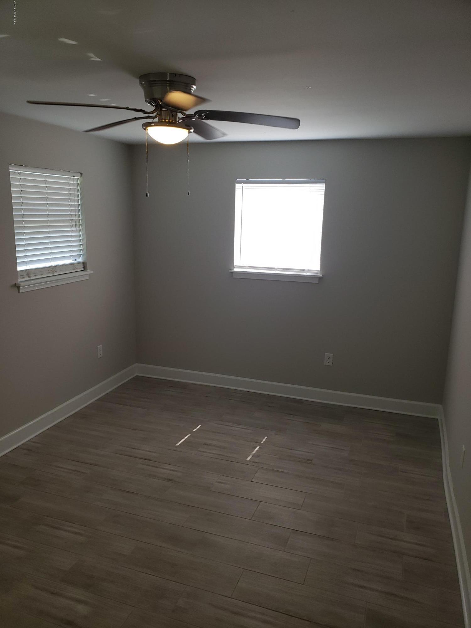 4030 Springwood Road Jacksonville, FL 32207 - Photo 6 of 19 a view of an empty room with wooden floor and a window