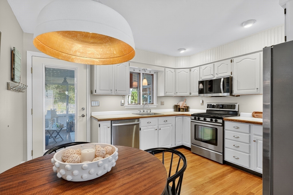 191 Hathaway Road Acushnet, MA 02743 - Photo 26 of 42 a kitchen with stainless steel appliances granite countertop a sink dishwasher a stove a refrigerator with a dining table and chairs