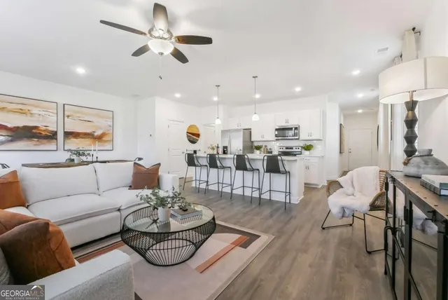 a living room with furniture and kitchen view