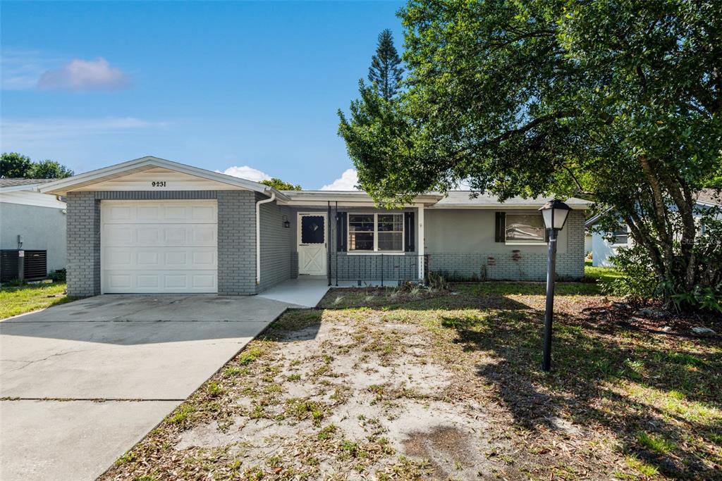 9231 St Regis Lane Port Richey, FL 34668 - Photo 1 of 1 a front view of a house with a yard