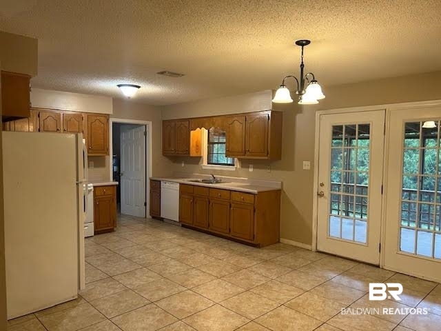 15602 Wrangler Road Summerdale, AL 36580 - Photo 8 of 14 Kitchen featuring white appliances, light countertops, a textured ceiling, hanging light fixtures, and a chandelier