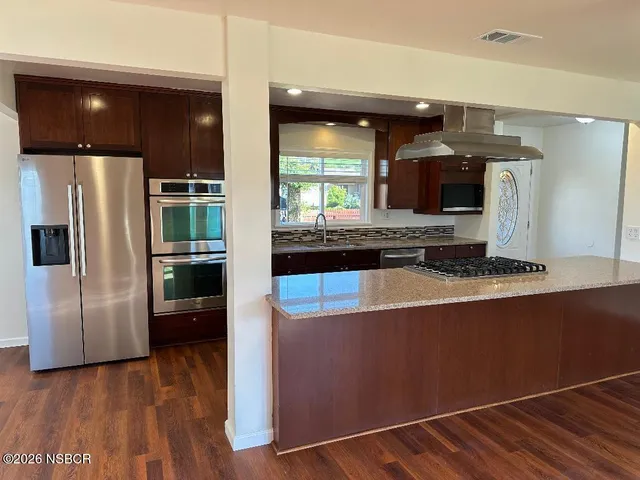 a kitchen with stainless steel appliances a refrigerator and a stove top oven